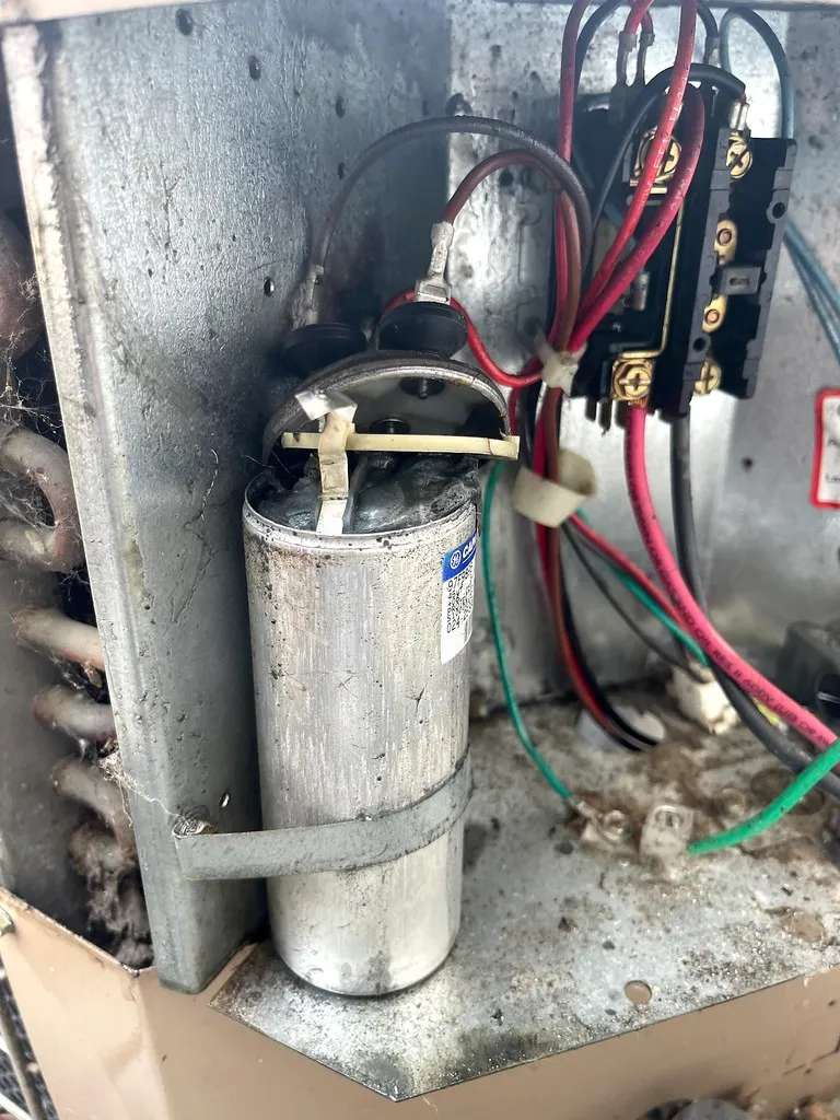 A bulging, failed run capacitor removed from an air conditioning system A bulging, failed run capacitor removed from an air conditioning system