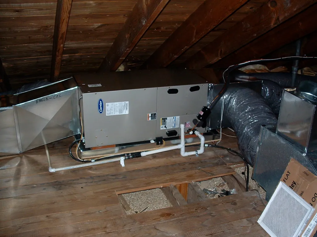 An air handler installed in a home attic, connected to insulated ductwork between the roof rafters. An air handler installed in a home attic, connected to insulated ductwork between the roof rafters.